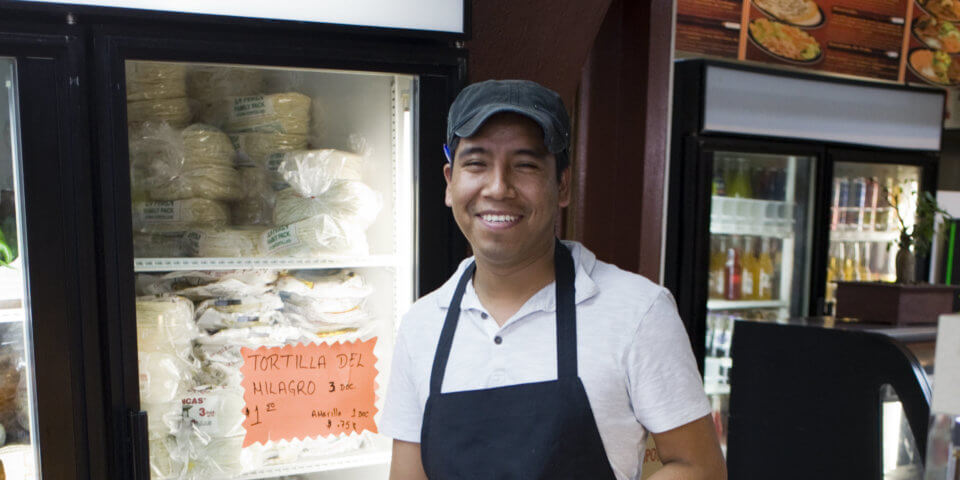 Austin grocery clerk holding avocado Taqueria